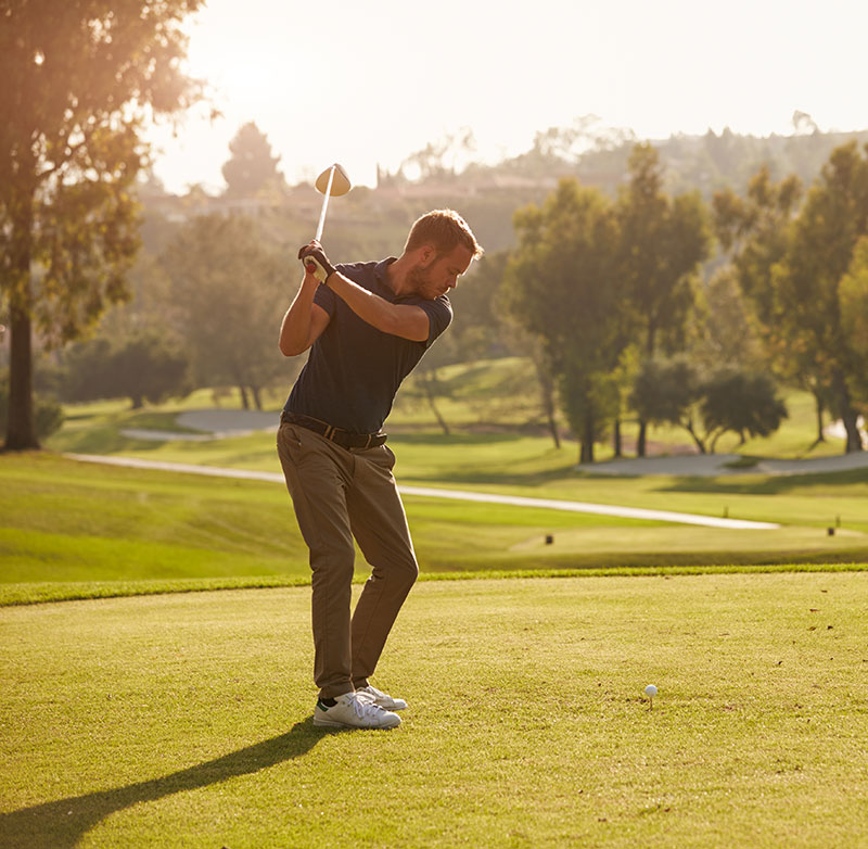 male golfer lining up tee shot on golf course